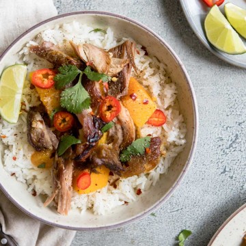 Round bowl filled with rice, Asian pork shoulder and garnishes