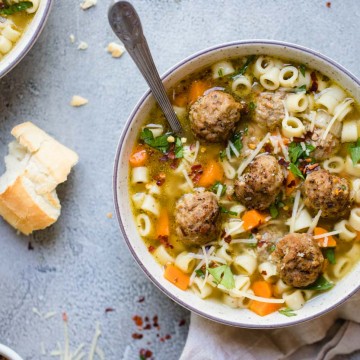 Bowl of meatball and pasta soup with crusty bread