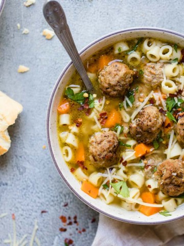 Bowl of meatball and pasta soup with crusty bread