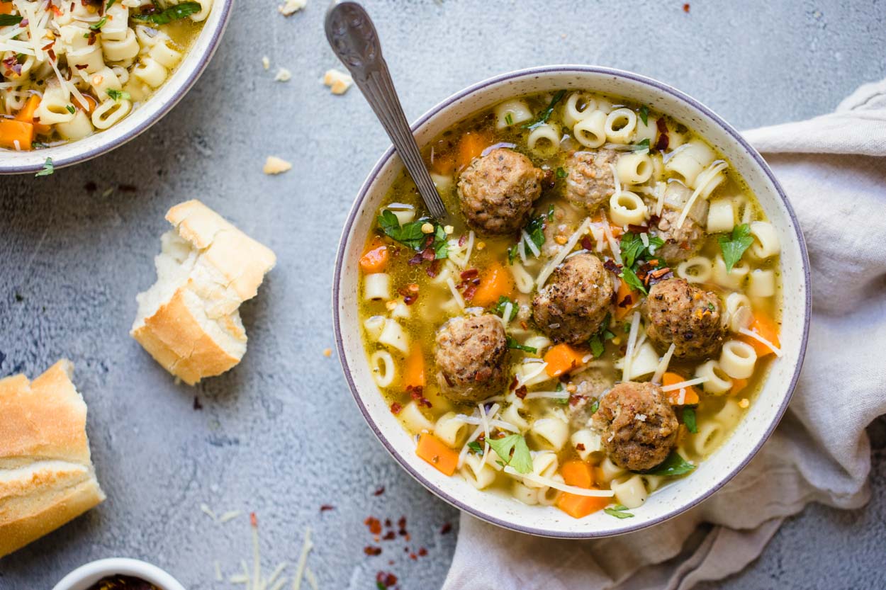 Bowl of meatball and pasta soup with crusty bread