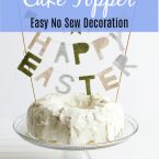 white frosted cake on a glass pedestal with a felt happy Easter banner