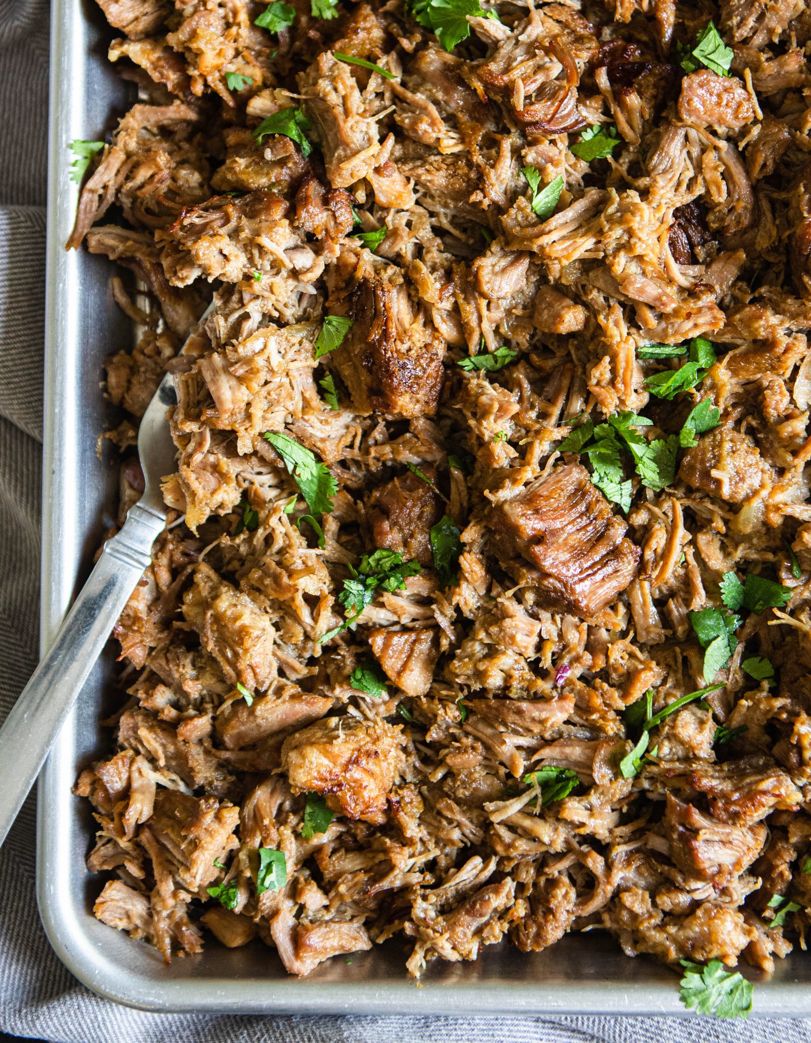 close up shot of Dutch oven pork carnitas on a silver baking tray