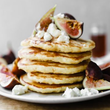 stack of basic pancakes topped with figs and ricotta cheese