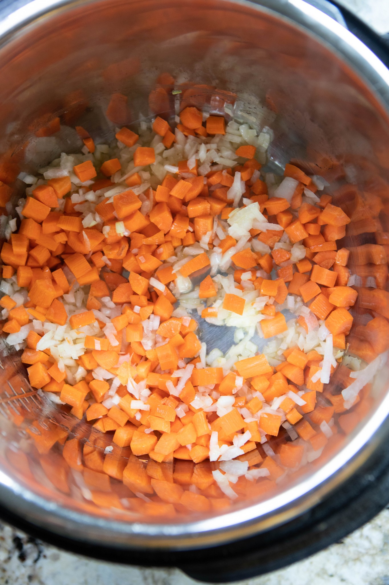 carrots and onions being sautéed in Instant Pot