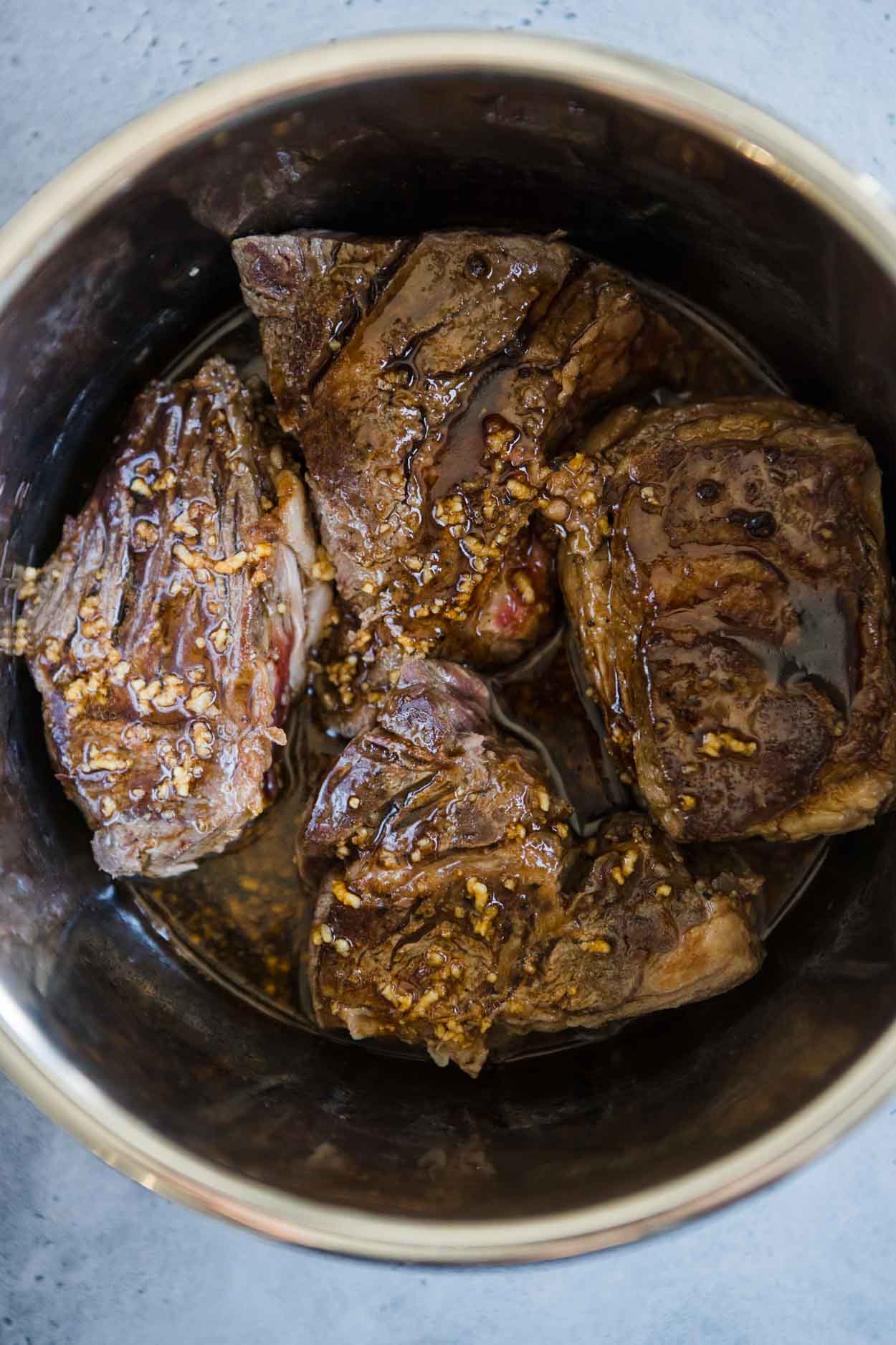 beef chuck roast in instant pot with sauce poured on top