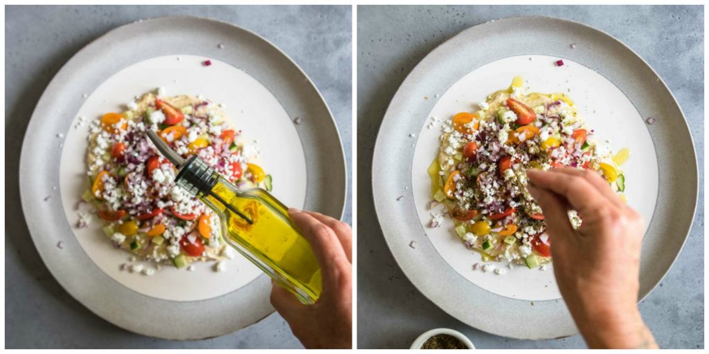 oil and spices being sprinkled on top of layered hummus dip