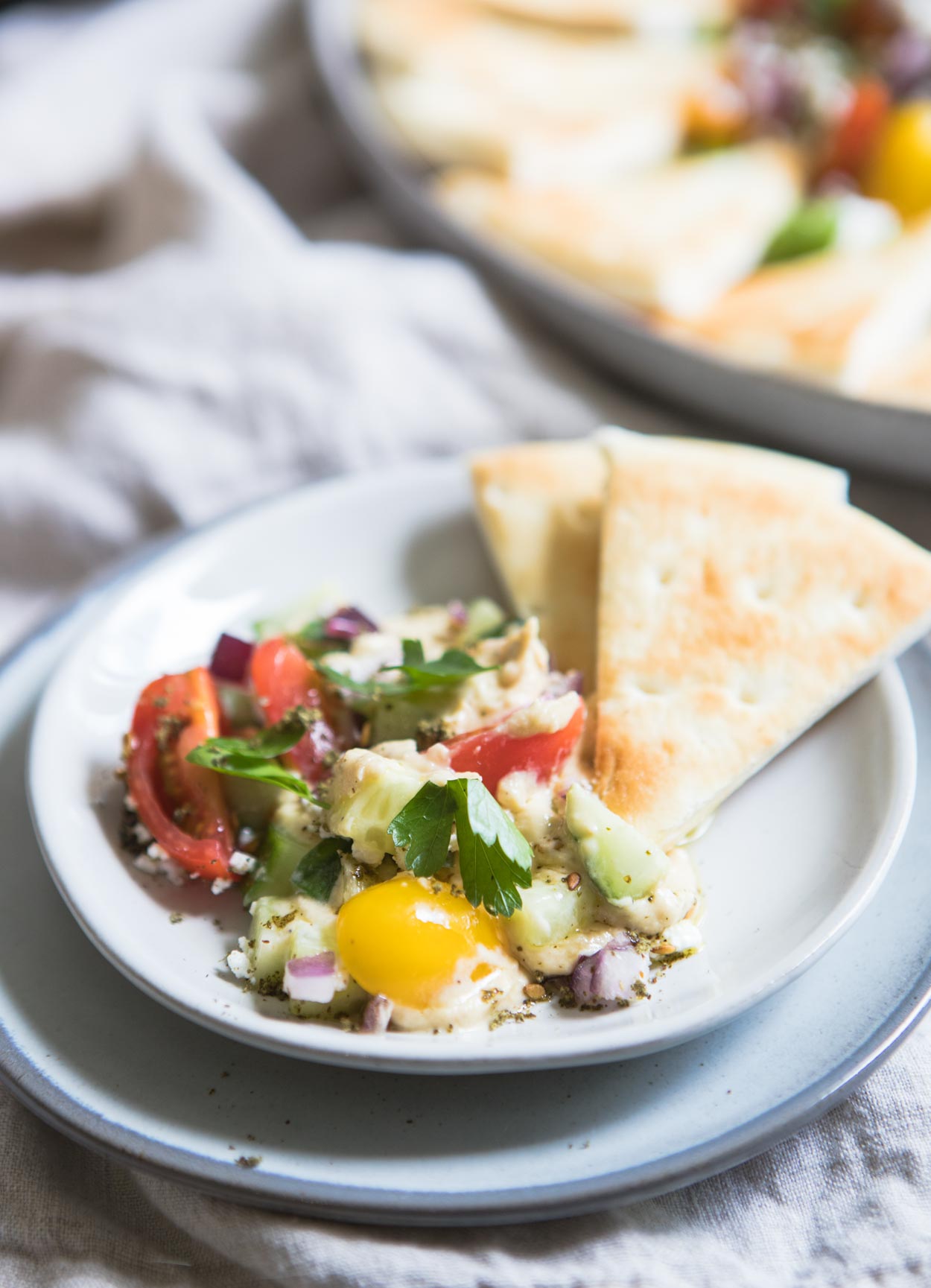 a couple pita wedges and hummus dip on a plate