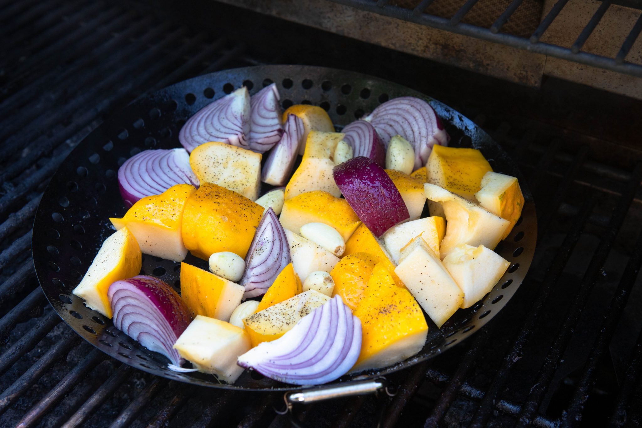 grilled vegetables in a grill basket on a bbq