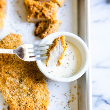a piece of air fryer chicken breast being dipped in ranch dressing