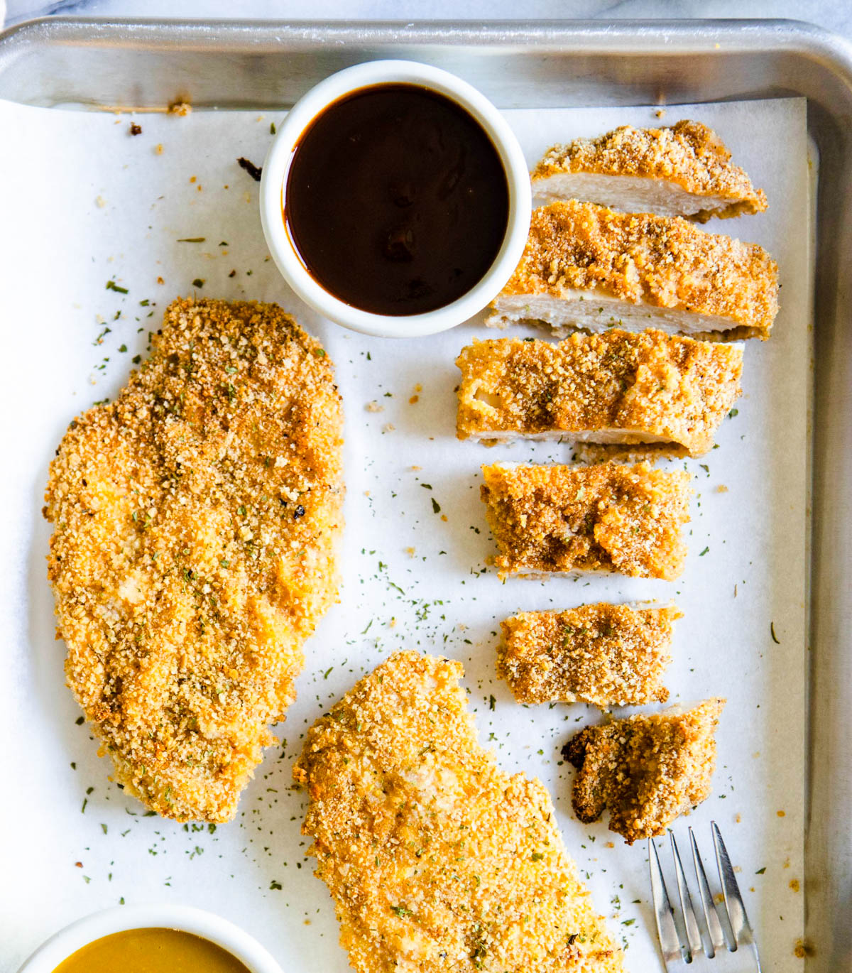 air fryer chicken cutlets on a parchment lined baking sheet