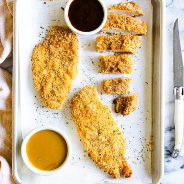 air fryer chicken cutlets on a sheet pan with 2 different types of sauces