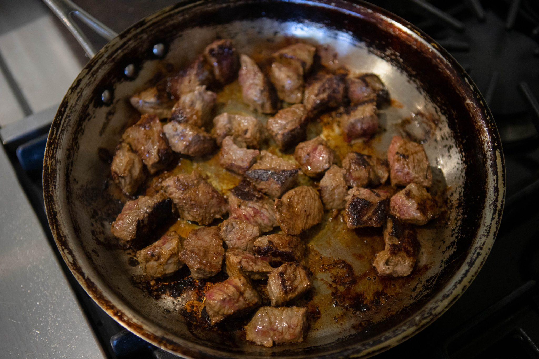 top sirloin steak tips searing in a hot sauté pan