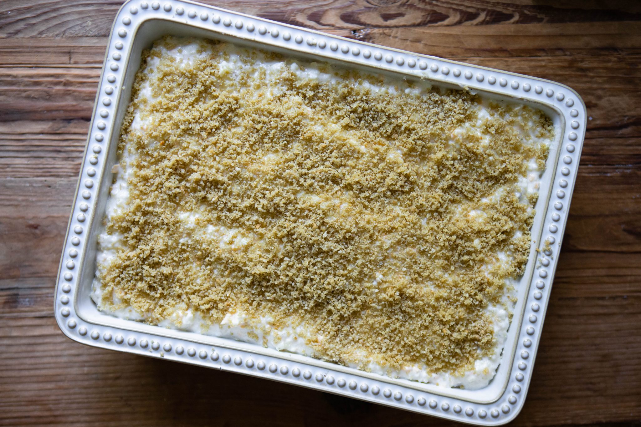 uncooked cheesy potato casserole in a casserole dish ready to go in the oven