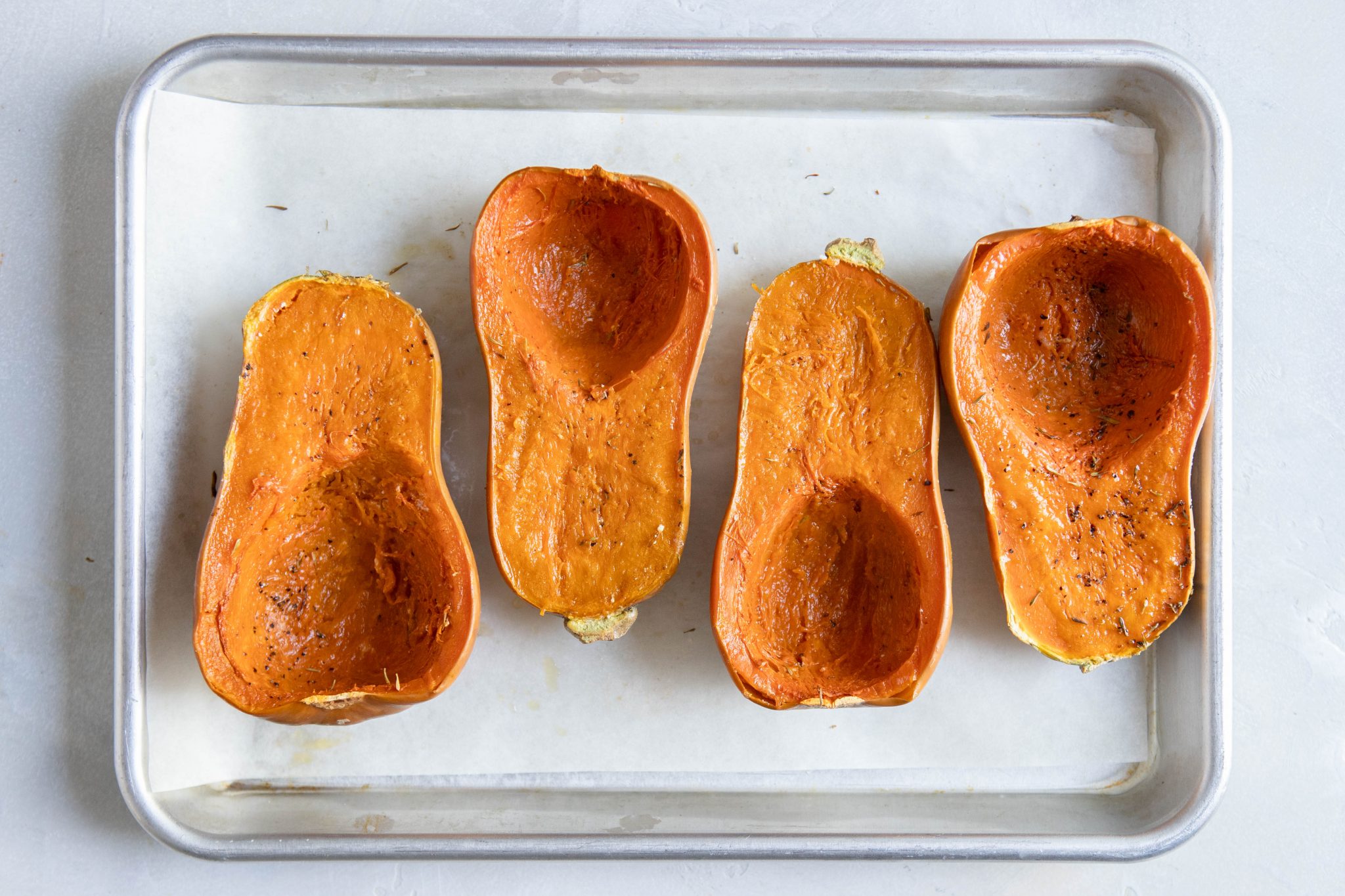 baked honeynut squash on a baking sheet with parchment paper