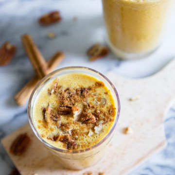 pumpkin spice smoothie in 2 glasses against marble