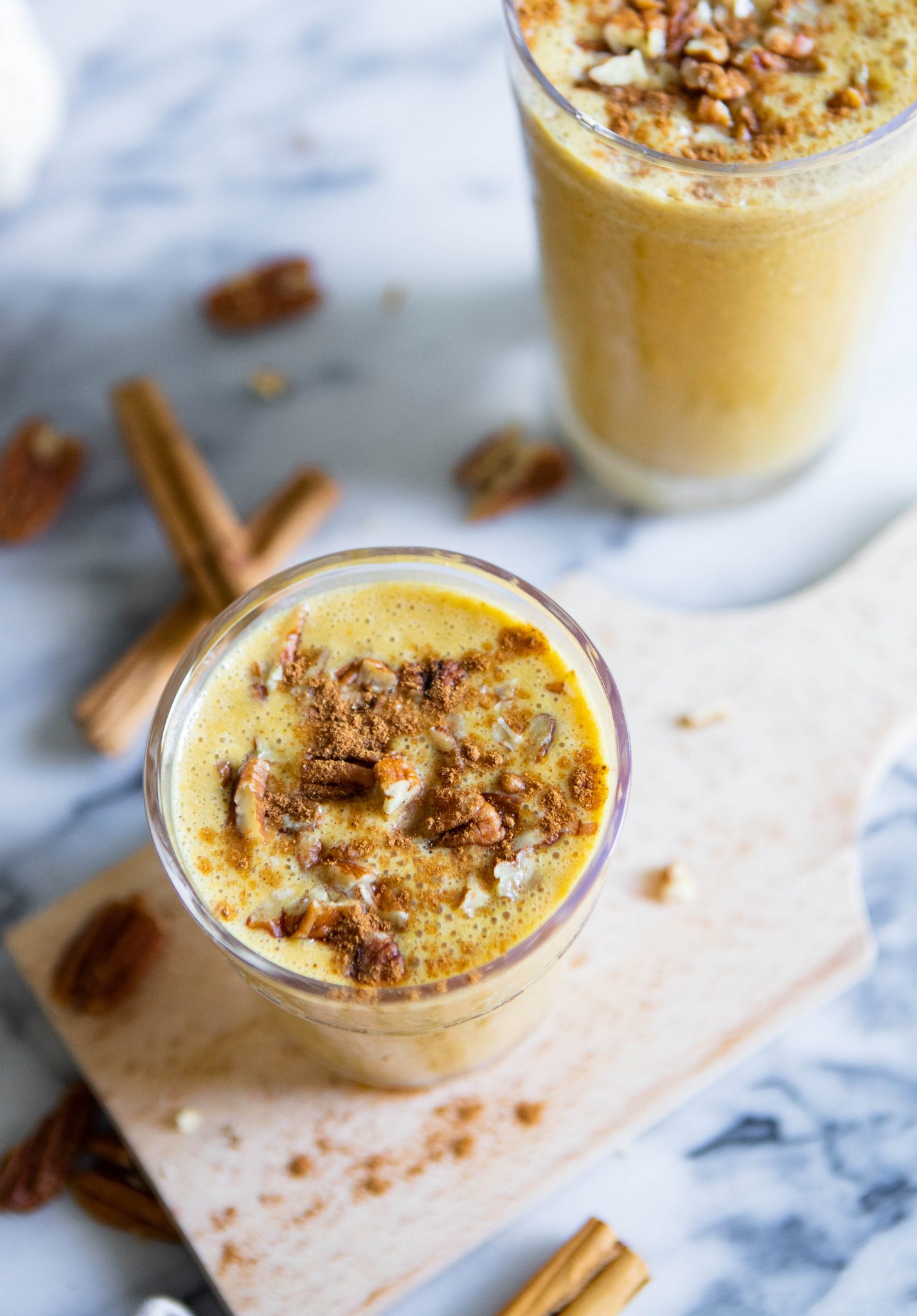 pumpkin spice smoothie in 2 glasses against marble