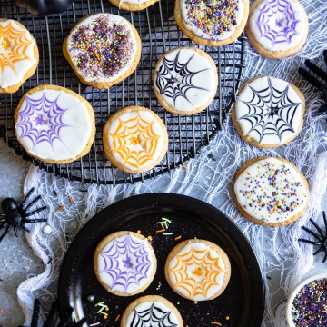 A spread of Halloween cookies decorated with Royal Icing and Spider Webs