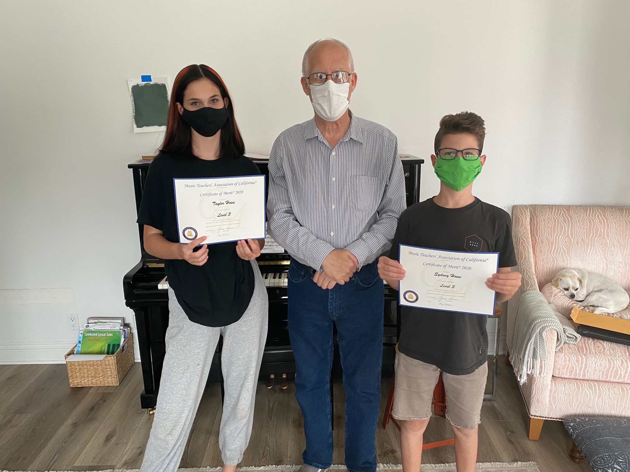 kids standing with piano teacher holding Certificate of Merit 