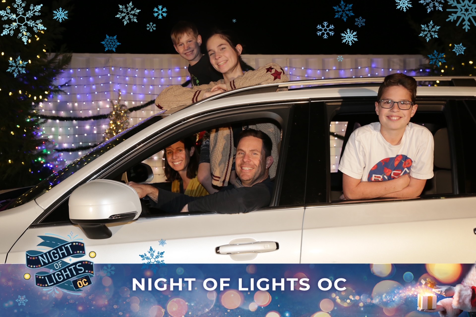 family in car at Night of Lights OC show