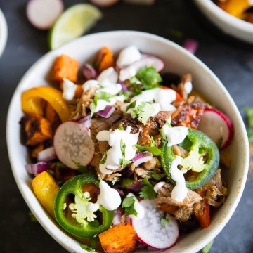 carnitas bowl with jalapeno and radish garnish, in a white bowl