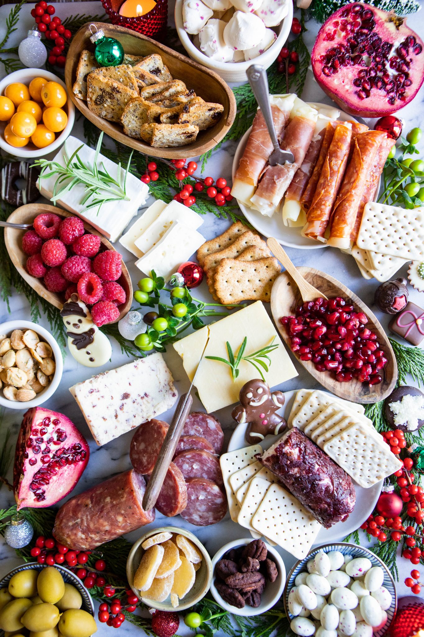 cured meat, blocks of cheese, fruit and nuts on a marble snack board