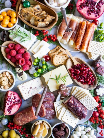 marble board filled with festive decor, cured meats and cheeses