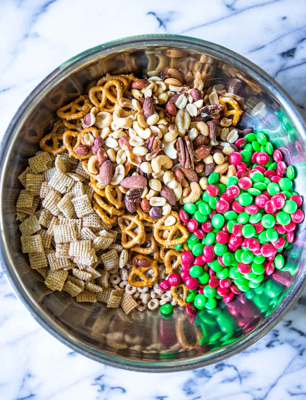 cereals, nuts and candy in a large mixing bowl