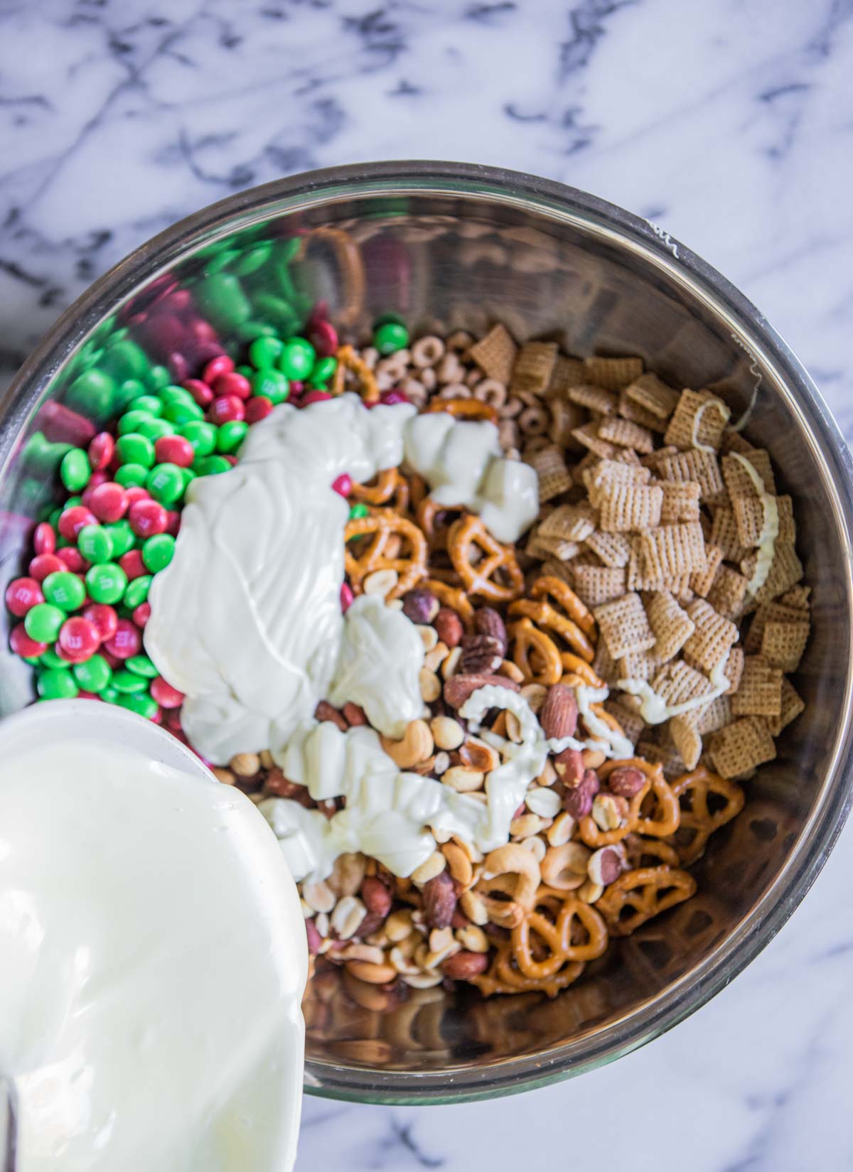 white chocolate melted being poured over a chex mix