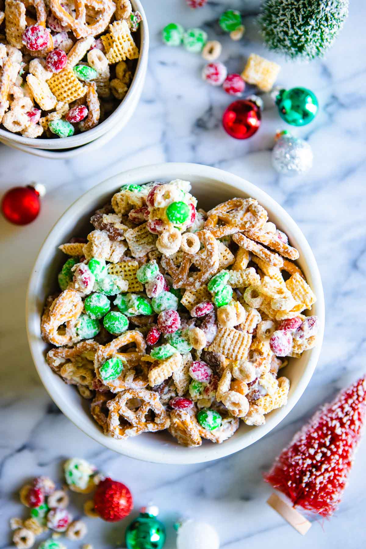 red and green white chocolate holiday chex mix in white bowls