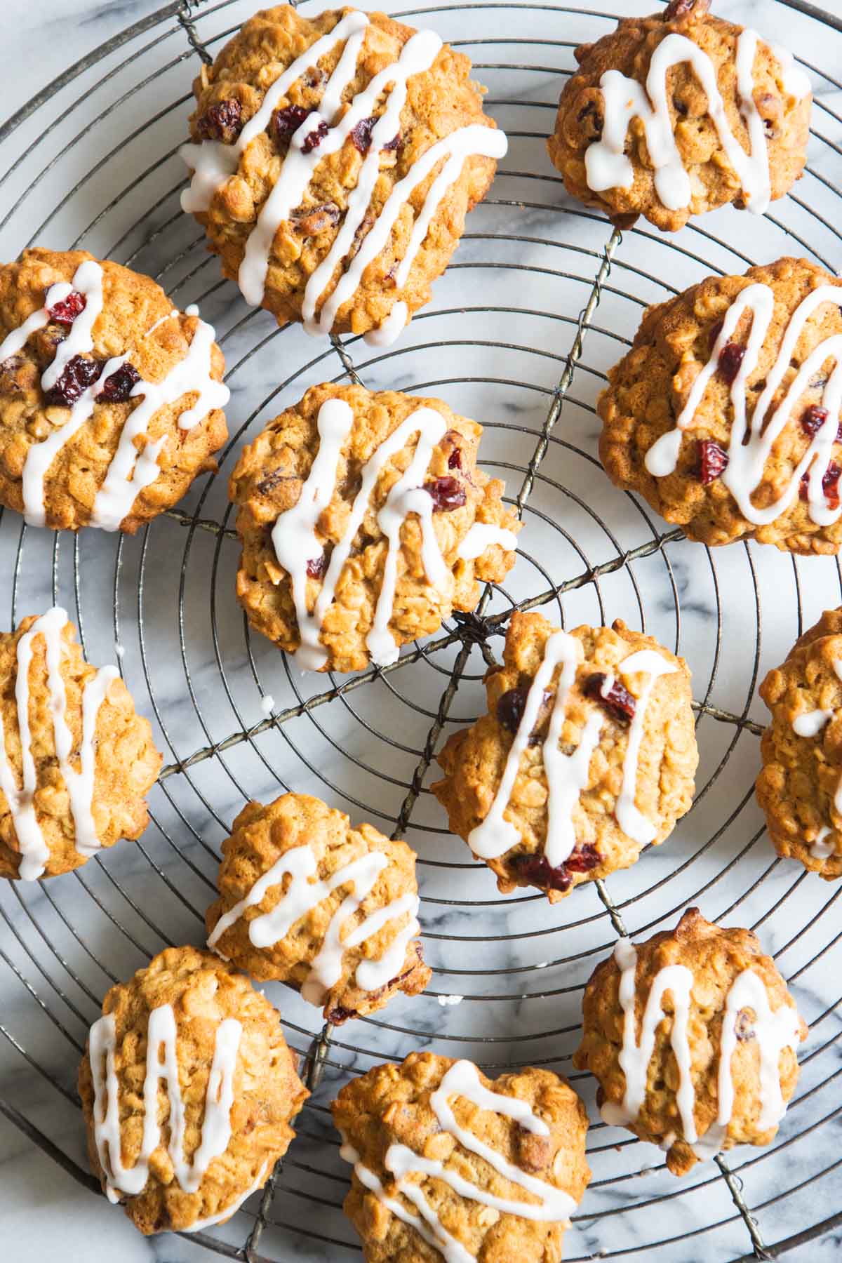 oatmeal craisin cookies with maple glaze on a vintage round cooling rack