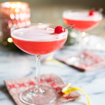 Pink cocktail with a foamy egg white top in a coupe glass