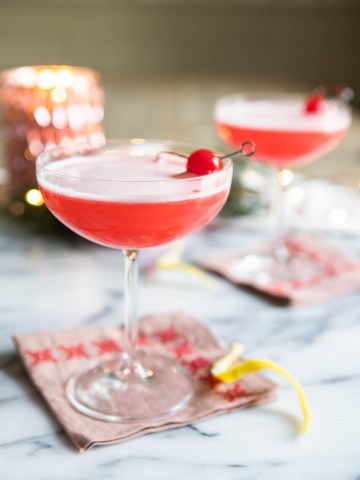 Pink cocktail with a foamy egg white top in a coupe glass