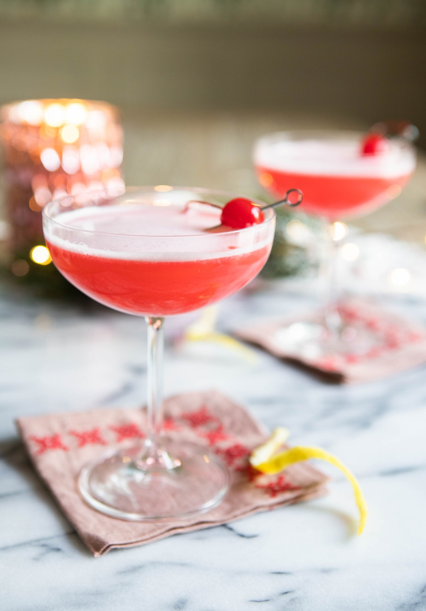 Pink cocktail with a foamy egg white top in a coupe glass