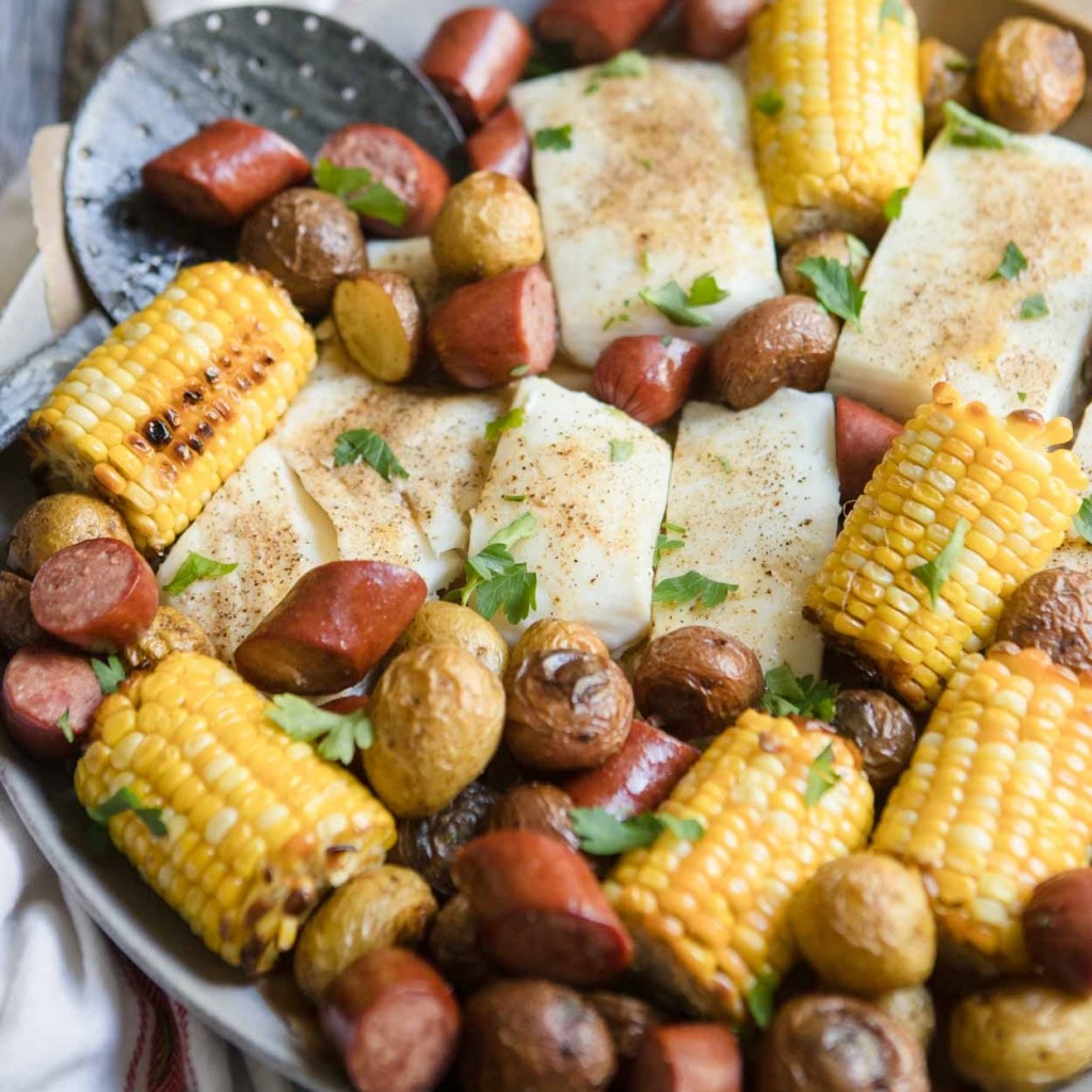 seafood and sausage bake on a platter with corn and potatoes