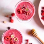 2 glasses filled with a bright pink smoothie on a pink table