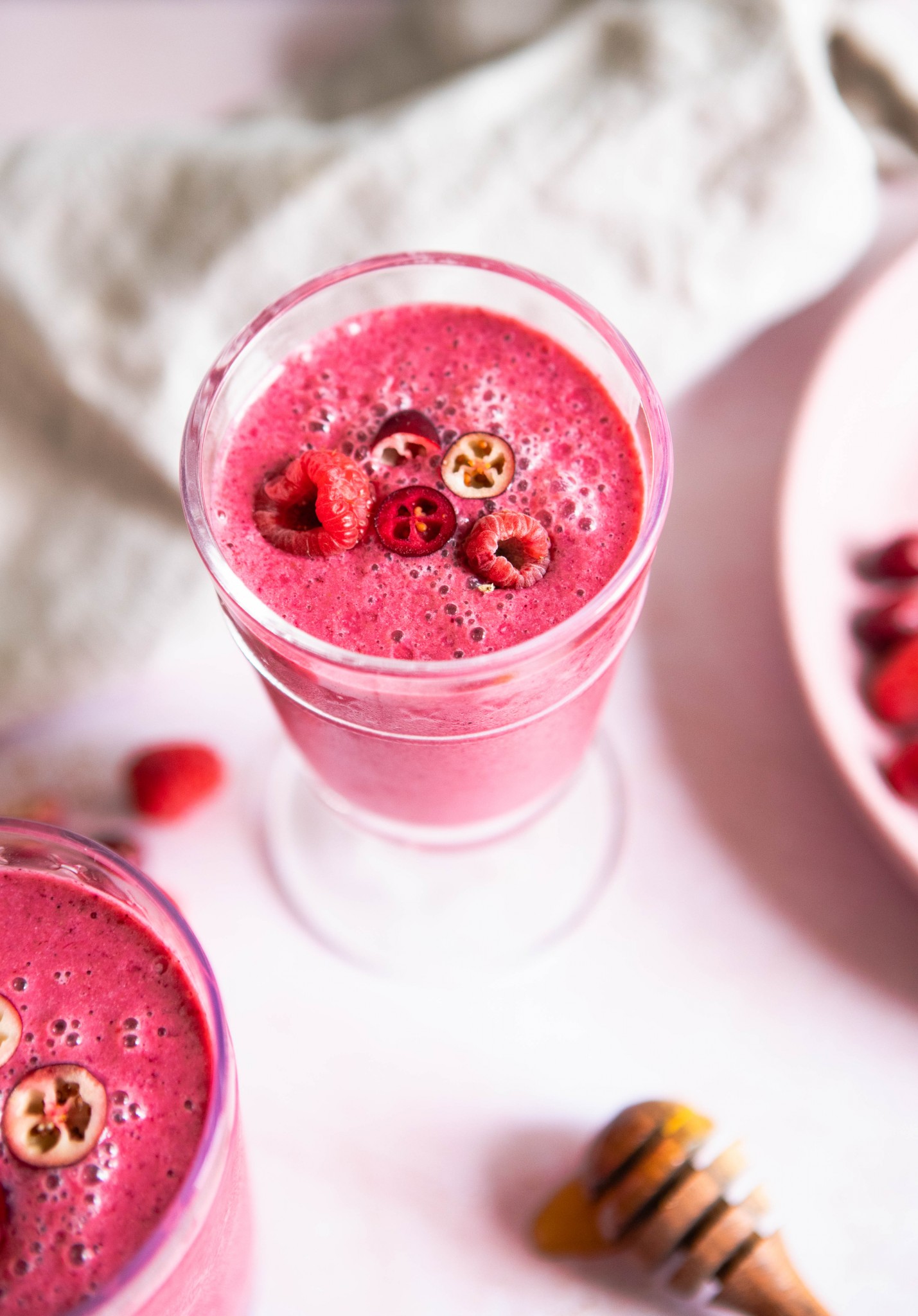 cranberry and berry smoothie in a glass with garnishes