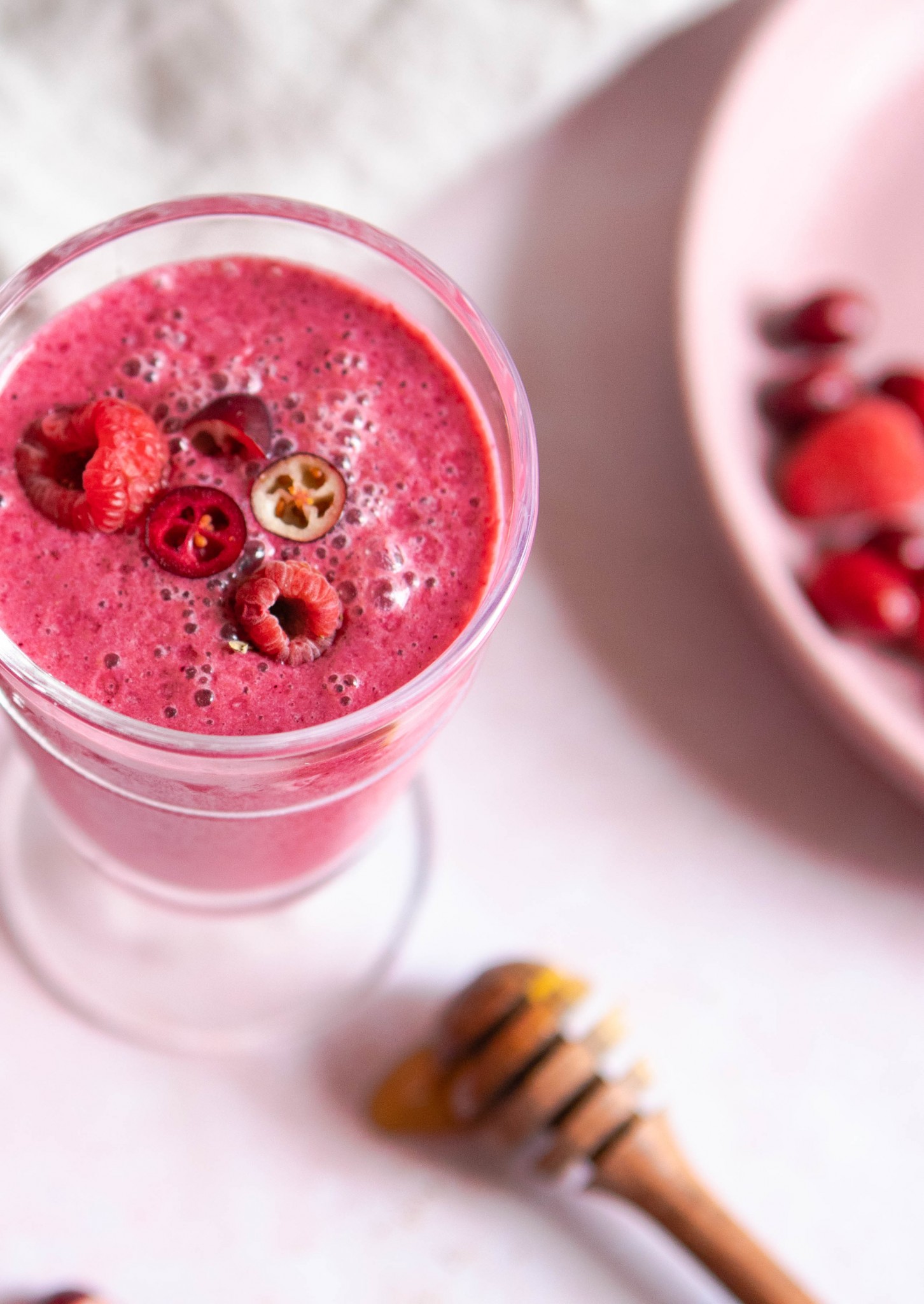 close up of a cranberry smoothie garnished with berries and cranberries