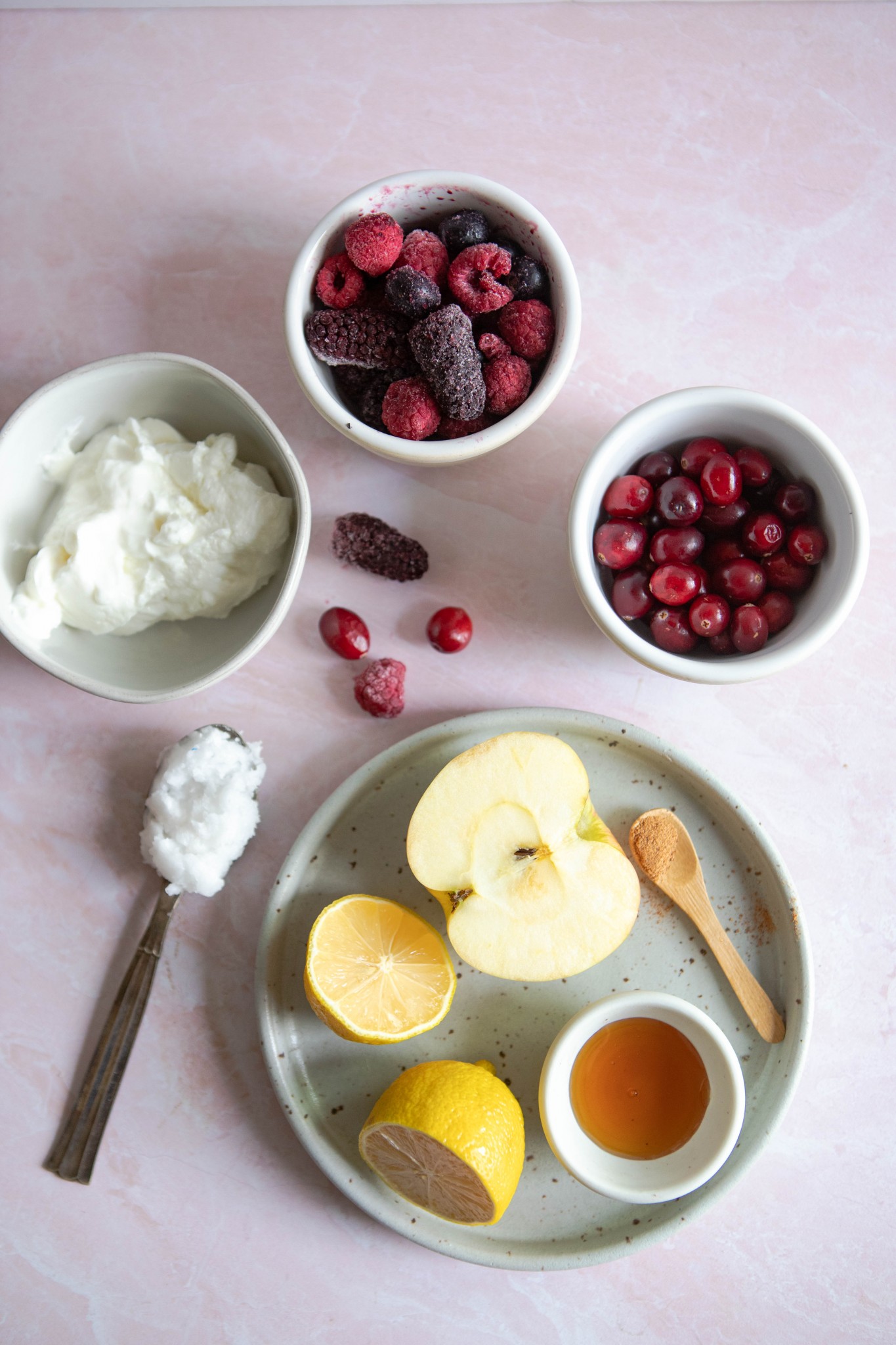 cranberry smoothie recipe ingredients in little white bowls against a pink backdrop