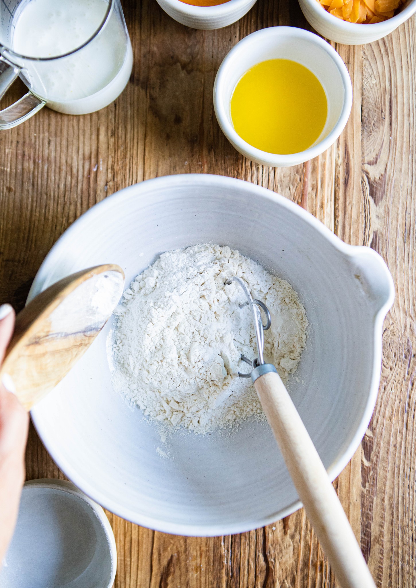 salt, sugar, baking powder and flour poured into a white mixing bowl