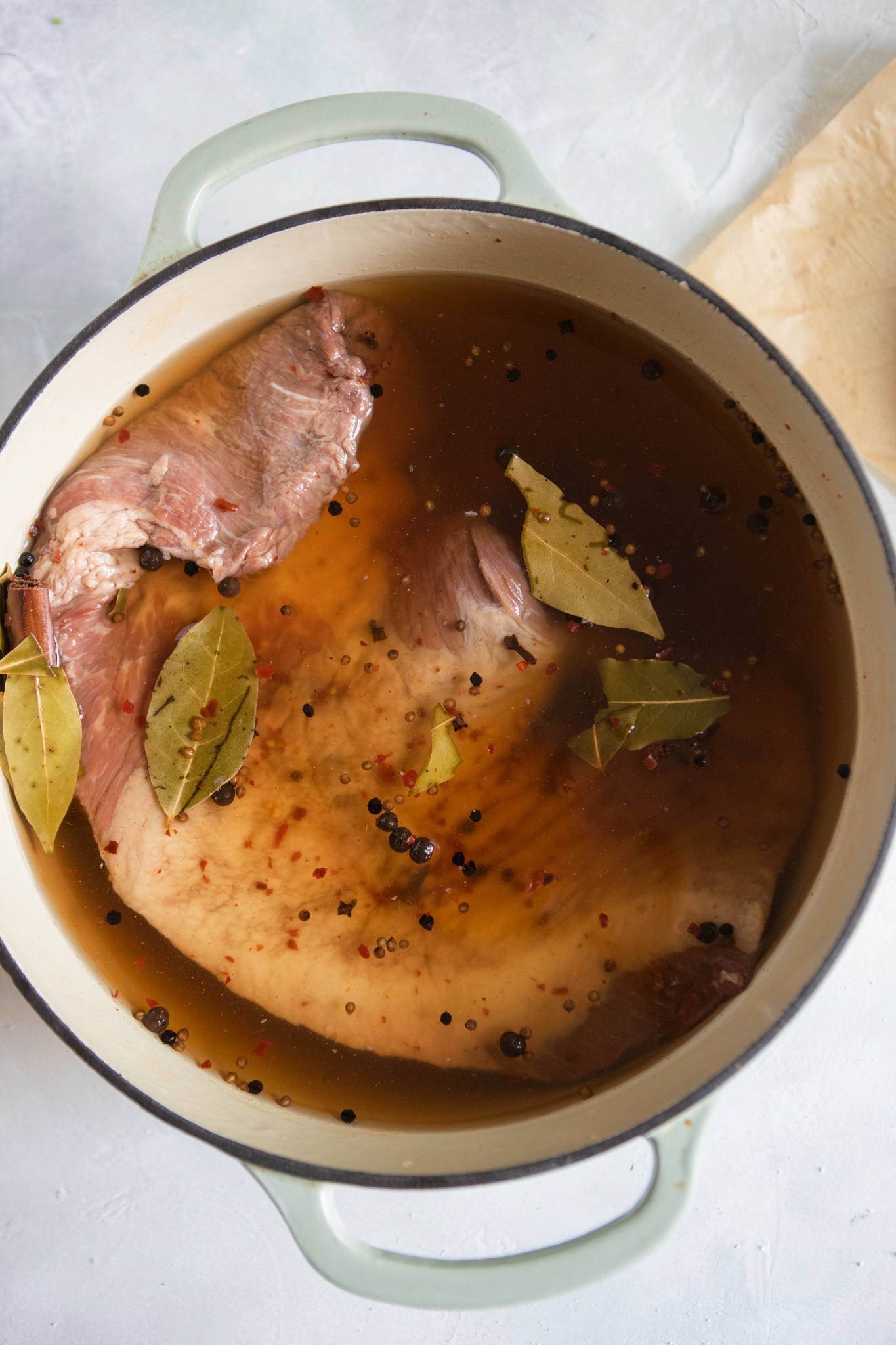 beef brisket in water bath of brine to make corned beef