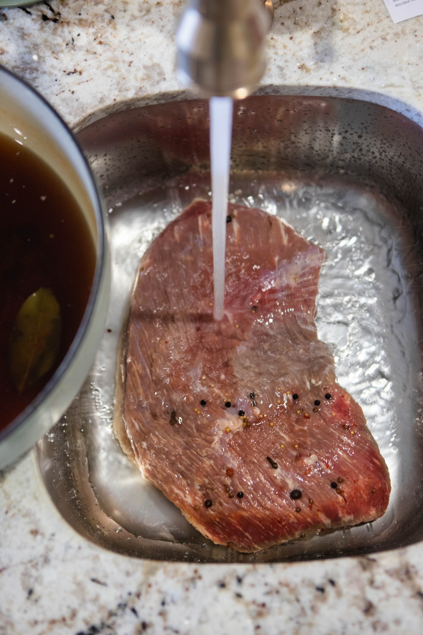 water running over a beef brisket that has just been brined 