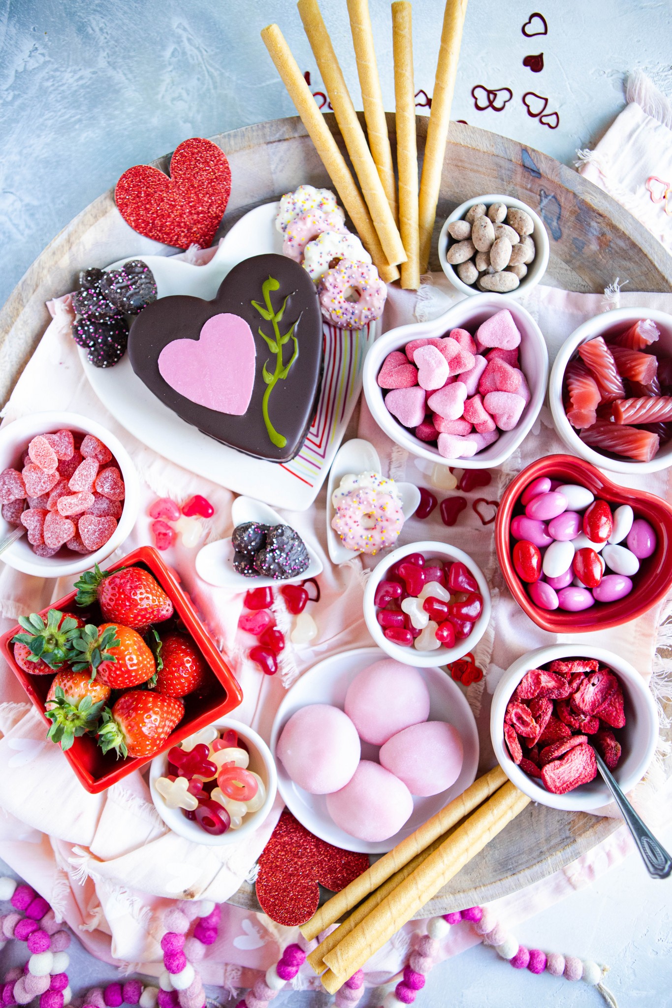 Valentine's dessert charcuterie board filled with pink and red candies, cookies and cakes