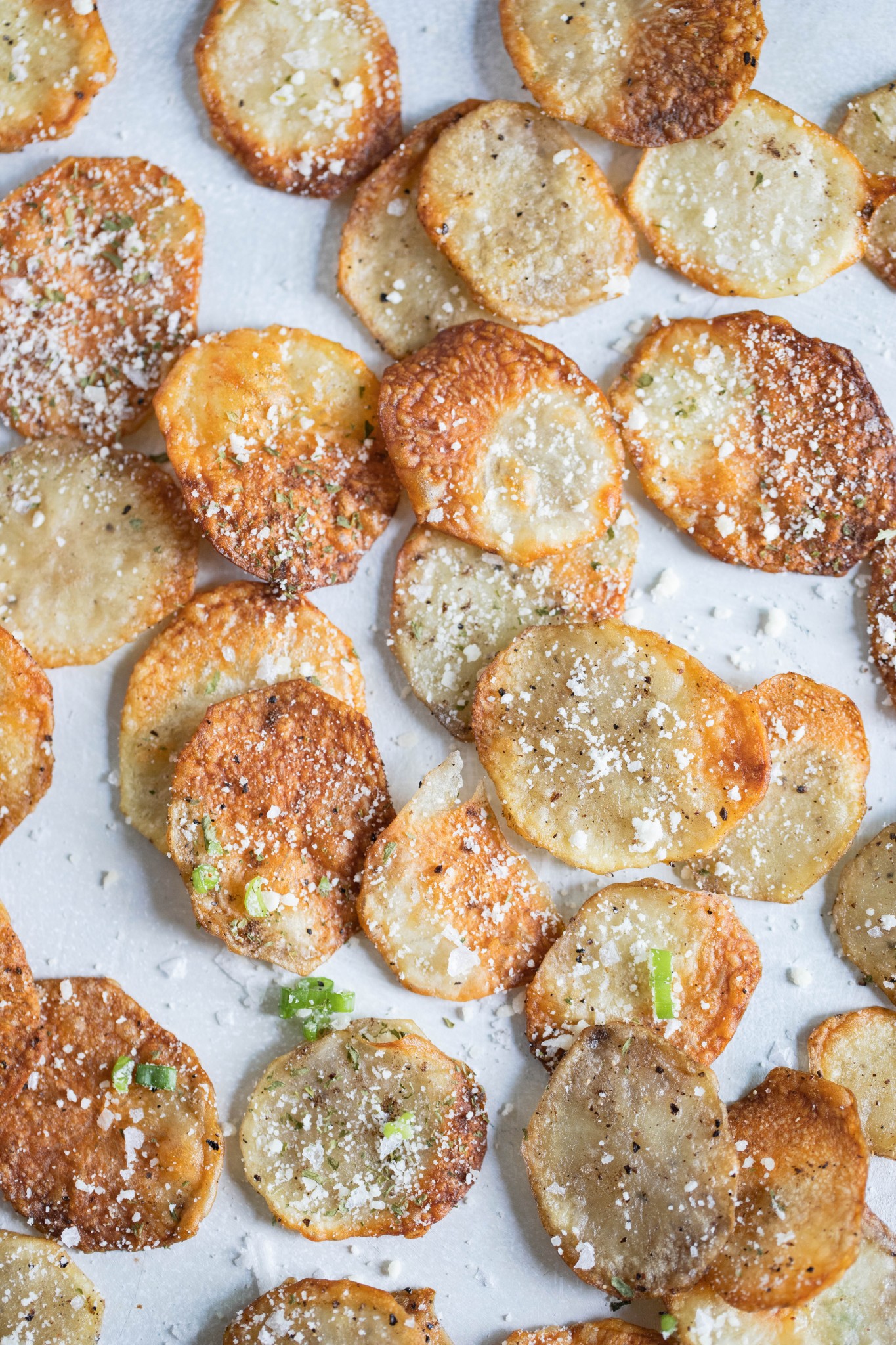 homemade potato chips in air fryer sprinkled with truffle seasoning and parmesan cheese