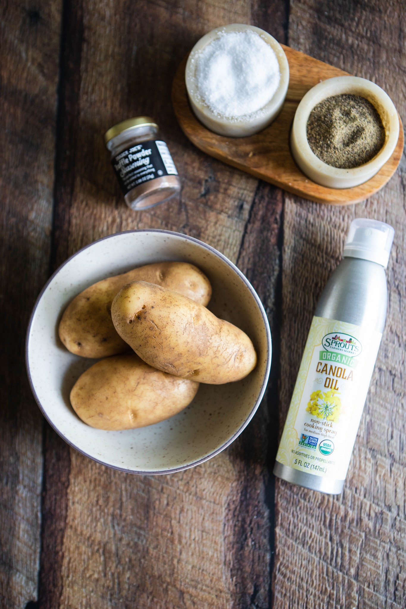 Idaho potatoes, Trader Joe's truffle seasoning, oil and salt and pepper on a wood board