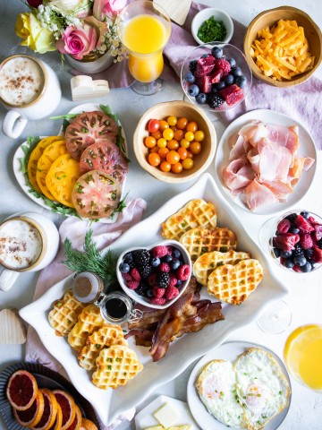 heart waffles and various snack and food items for a Valentine's Day breakfast