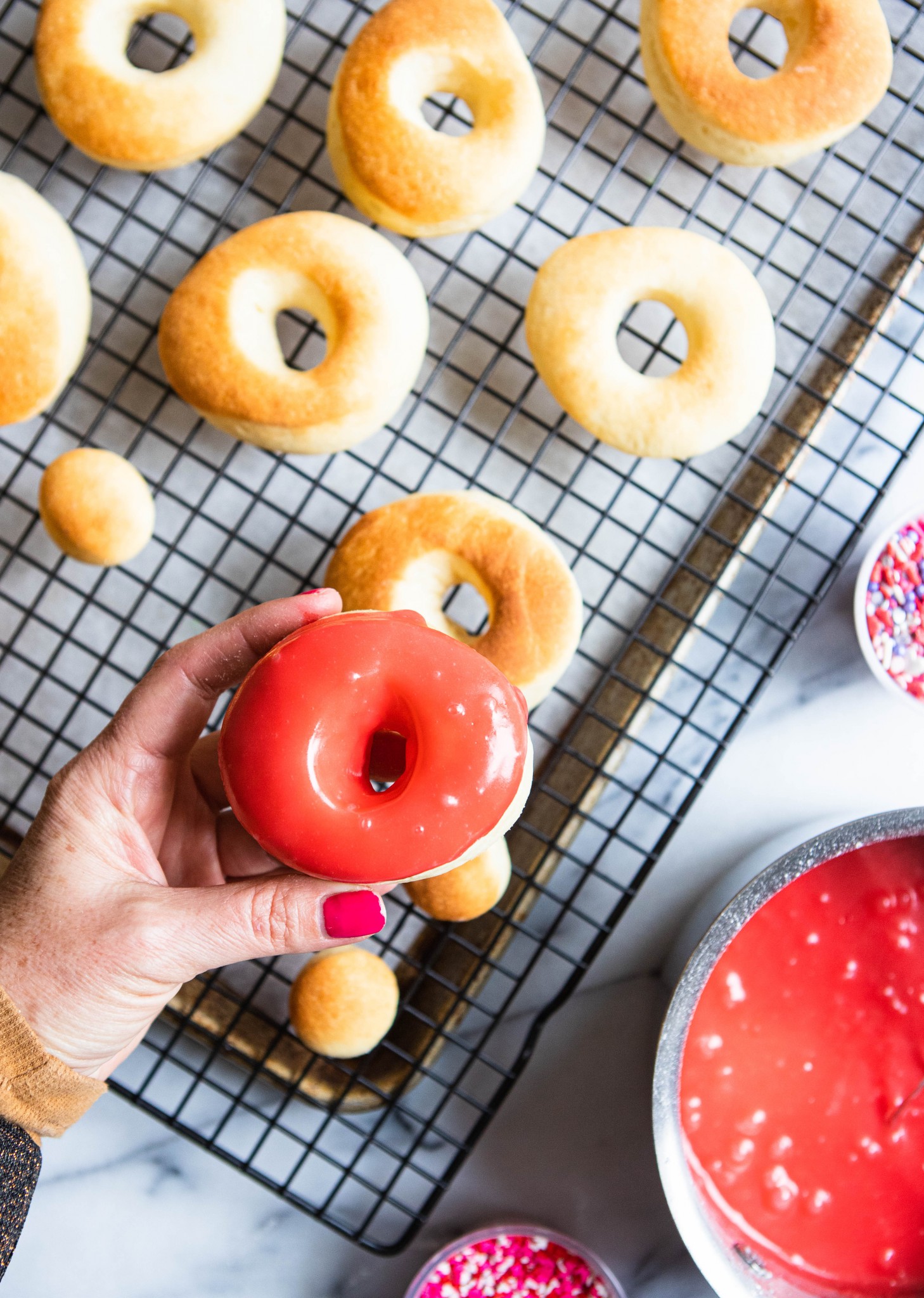 air fryer donuts ready to be glazed with red homemade glaze