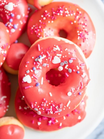 valentine donuts in air fryer sprinkled with red glaze and heart sprinkles
