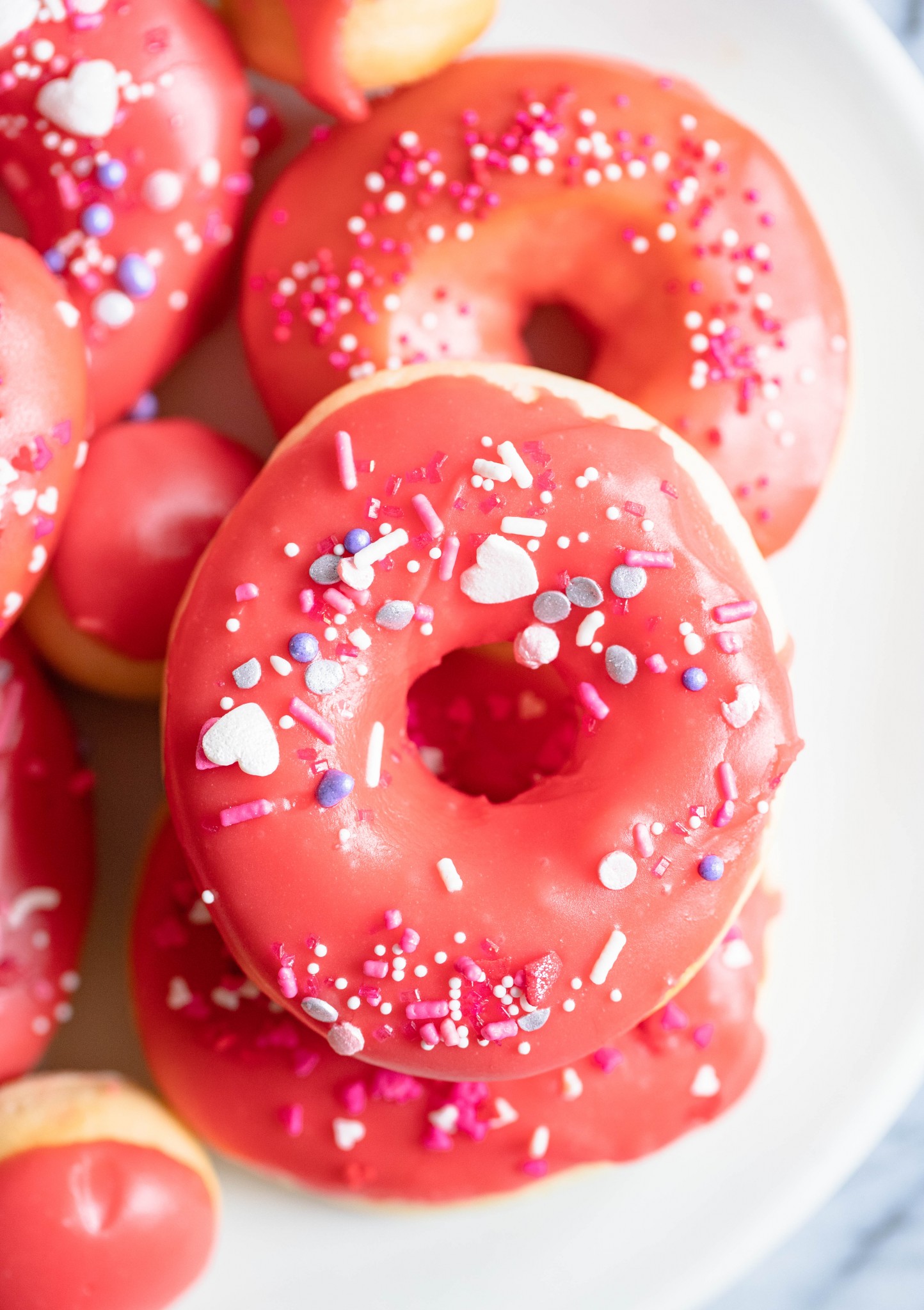 donuts sprinkled with red glaze and heart sprinkles