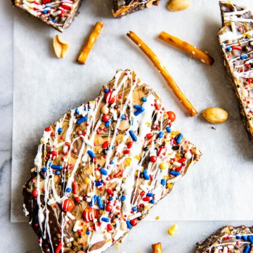 close up of a piece of dark chocolate bark with peanut butter and pretzels