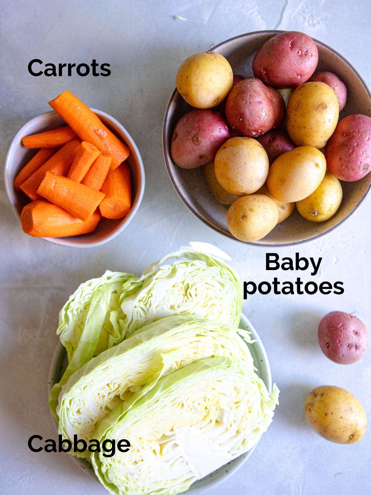 cabbage, potatoes and carrots on a white board